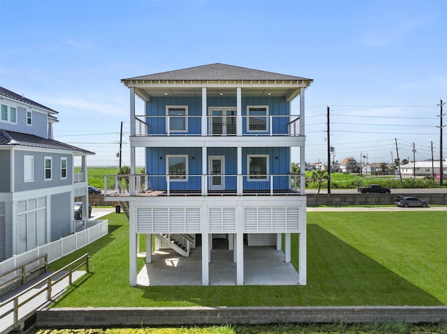 rear view of property with a lawn, a patio area, and a balcony