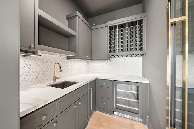 kitchen featuring wine cooler, gray cabinets, a sink, and open shelves