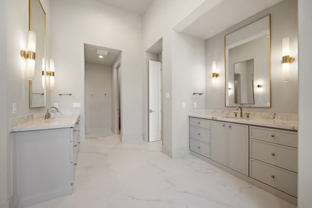 full bath with marble finish floor, two vanities, and a sink