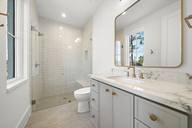 bathroom with toilet, a shower stall, recessed lighting, and vanity