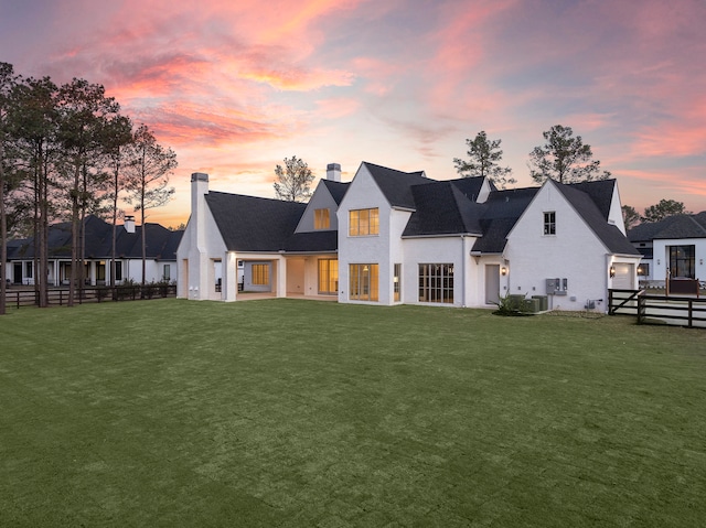 view of front of property with fence, cooling unit, and a yard