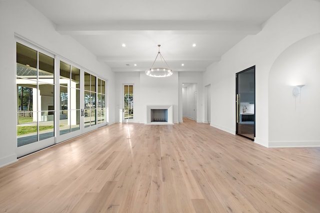 unfurnished living room with beam ceiling, a fireplace, recessed lighting, light wood-style floors, and baseboards