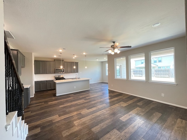 unfurnished living room featuring sink, a textured ceiling, ceiling fan, and dark wood-type flooring