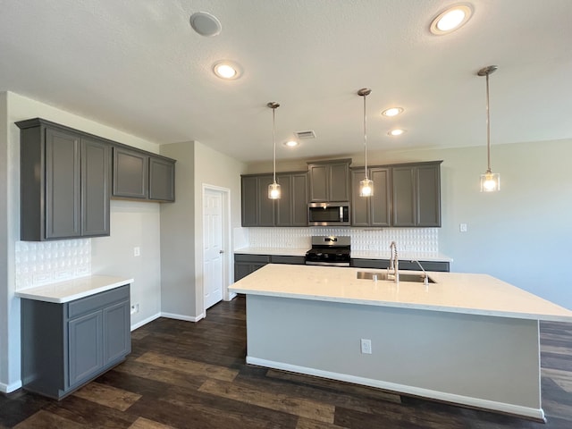 kitchen featuring stainless steel appliances, sink, hanging light fixtures, decorative backsplash, and dark hardwood / wood-style flooring