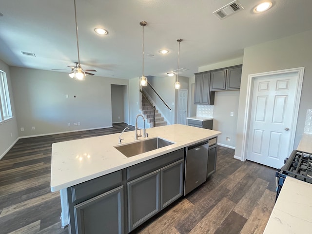 kitchen with stainless steel appliances, decorative backsplash, a kitchen island with sink, dark wood-type flooring, and ceiling fan