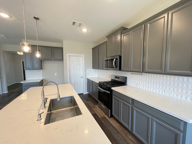 kitchen with stainless steel appliances, sink, backsplash, decorative light fixtures, and dark hardwood / wood-style floors