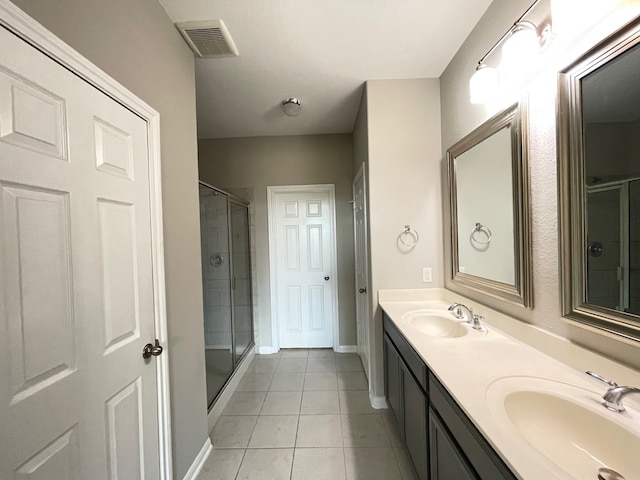 bathroom featuring walk in shower, tile patterned flooring, and dual vanity