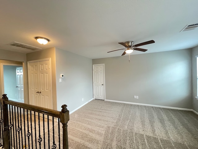 unfurnished room with carpet and ceiling fan