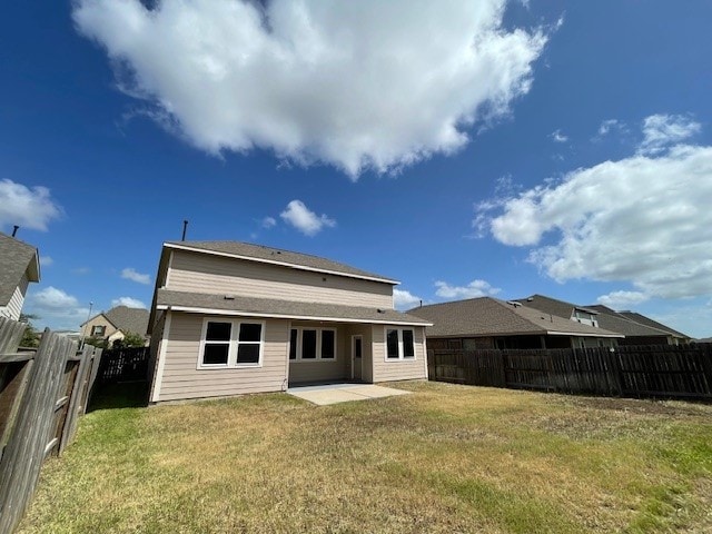 back of house featuring a patio and a lawn