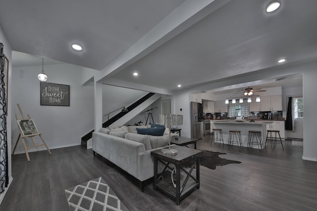 living room featuring ceiling fan, beamed ceiling, and dark hardwood / wood-style flooring