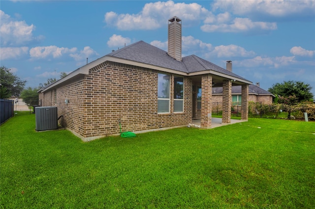 back of property with a lawn, a patio area, and central air condition unit