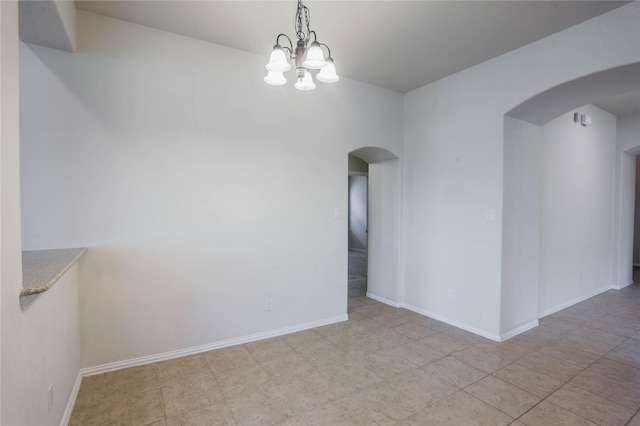 empty room with a chandelier and light tile patterned floors