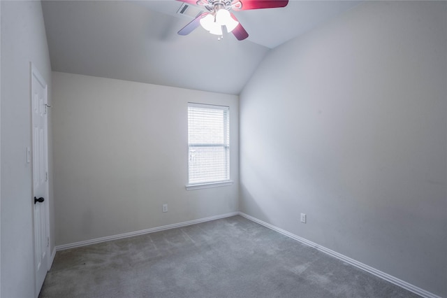 empty room featuring dark carpet, vaulted ceiling, and ceiling fan