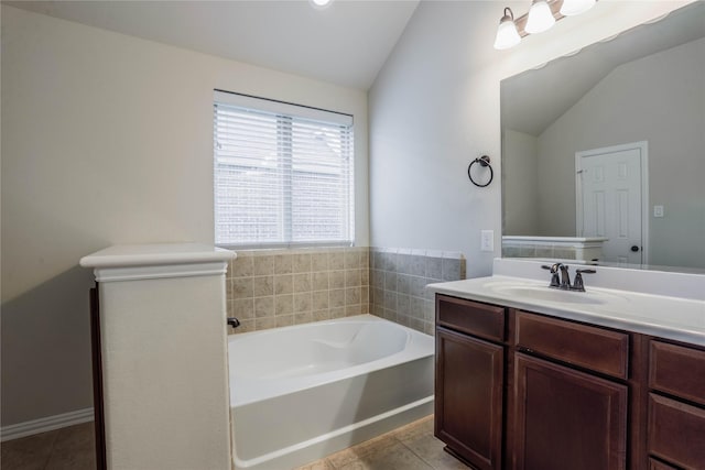 bathroom with tile patterned flooring, vanity, a tub, and lofted ceiling