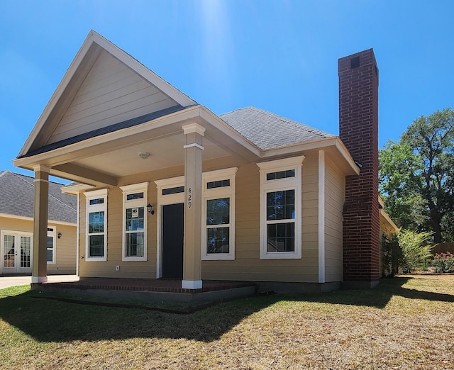 rear view of property with a porch and a yard