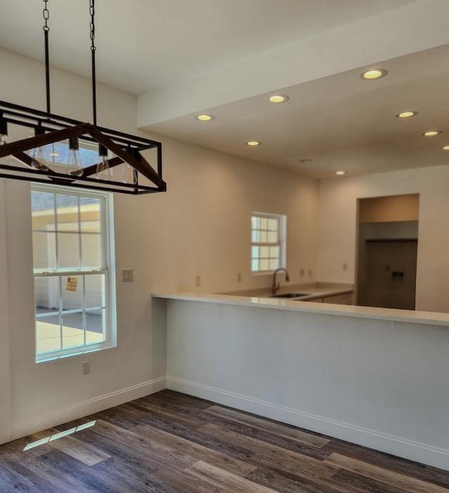 interior space with decorative light fixtures, dark hardwood / wood-style floors, and sink