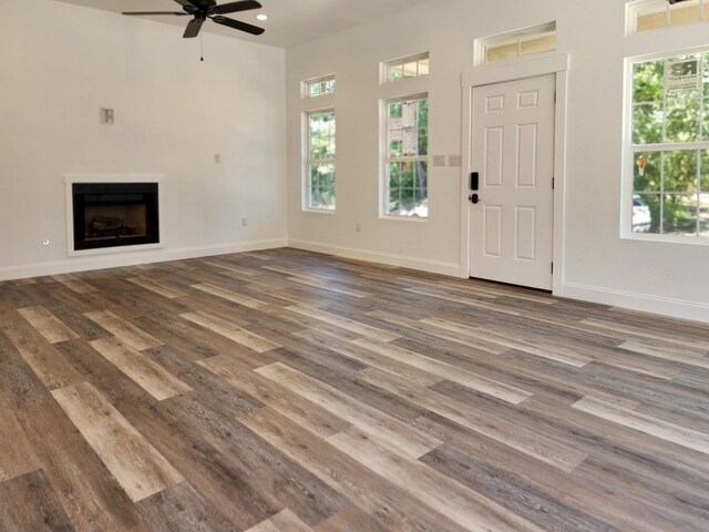 unfurnished living room with dark hardwood / wood-style floors and ceiling fan