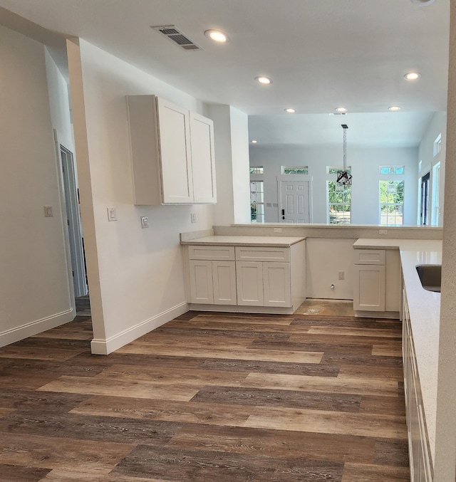 kitchen with white cabinetry, sink, an inviting chandelier, dark hardwood / wood-style flooring, and pendant lighting