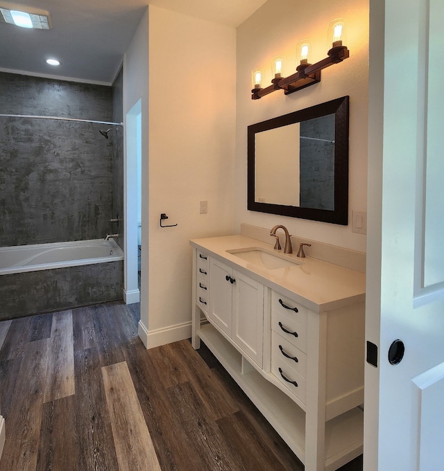 bathroom featuring hardwood / wood-style floors, vanity, and tiled shower / bath combo