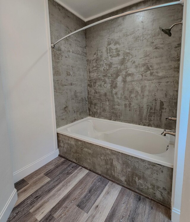 bathroom with tiled shower / bath combo and wood-type flooring