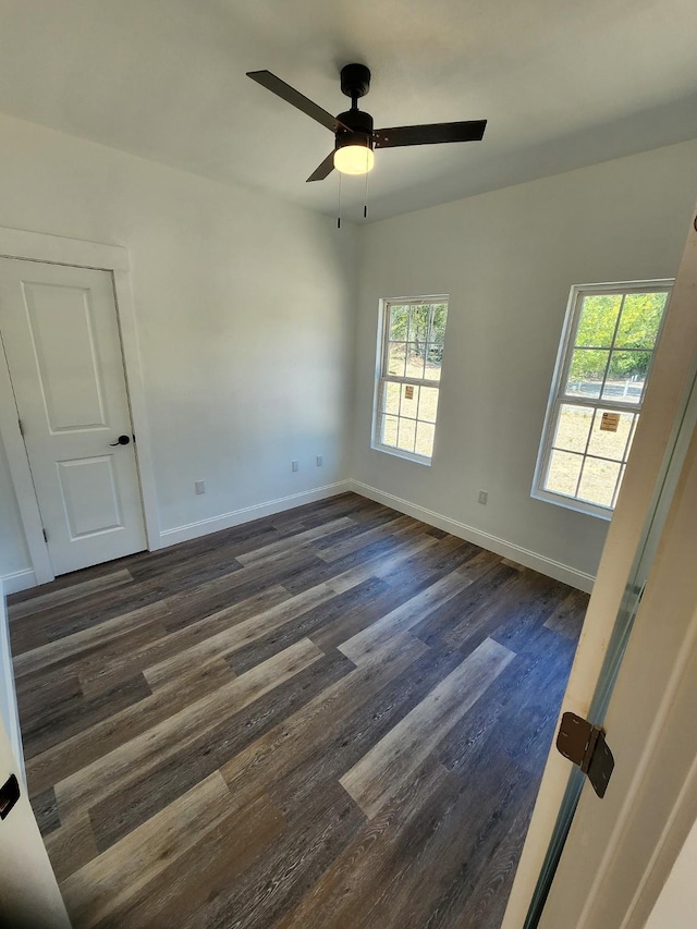 unfurnished room featuring ceiling fan and dark hardwood / wood-style flooring