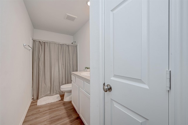 bathroom with vanity, toilet, and hardwood / wood-style floors