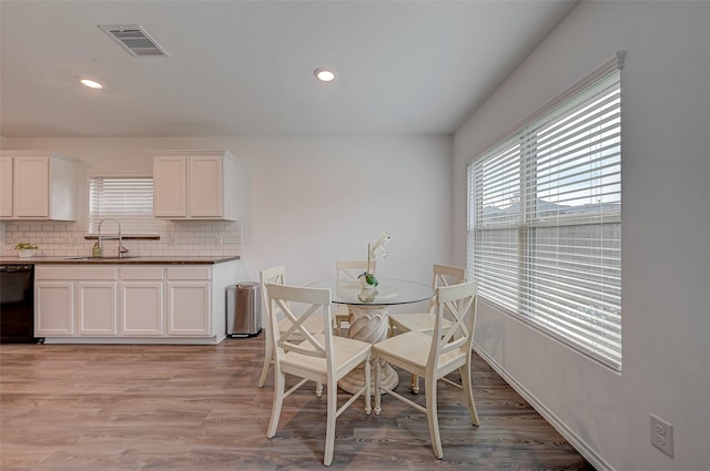 dining space with sink and light hardwood / wood-style floors