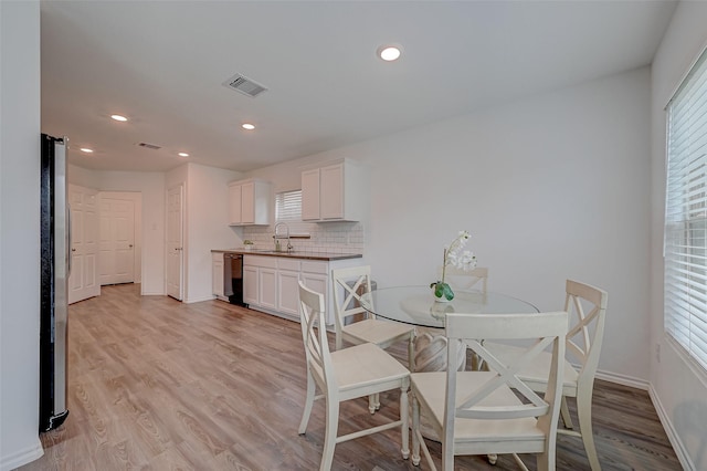 dining space featuring sink and light hardwood / wood-style flooring