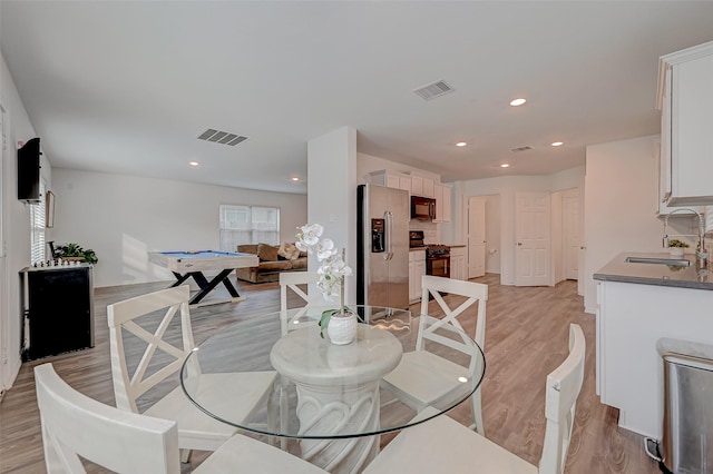 dining room with sink and light wood-type flooring