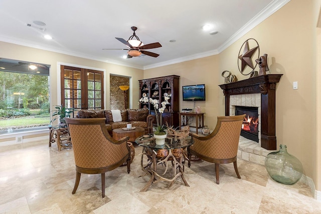 living room featuring ceiling fan, ornamental molding, a fireplace, and french doors