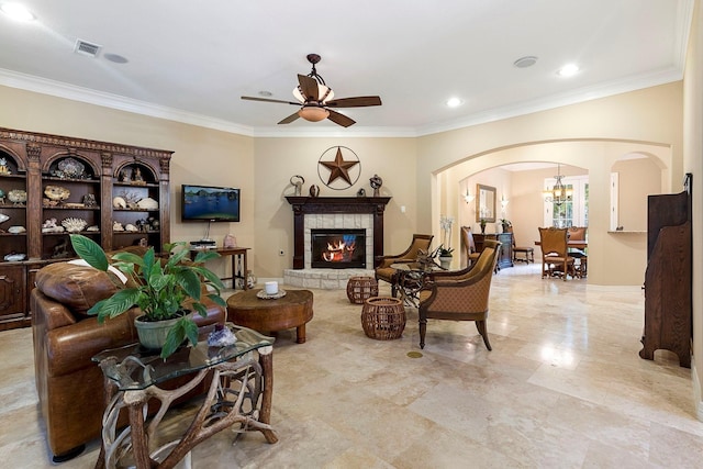 living room featuring ceiling fan with notable chandelier, ornamental molding, and a fireplace