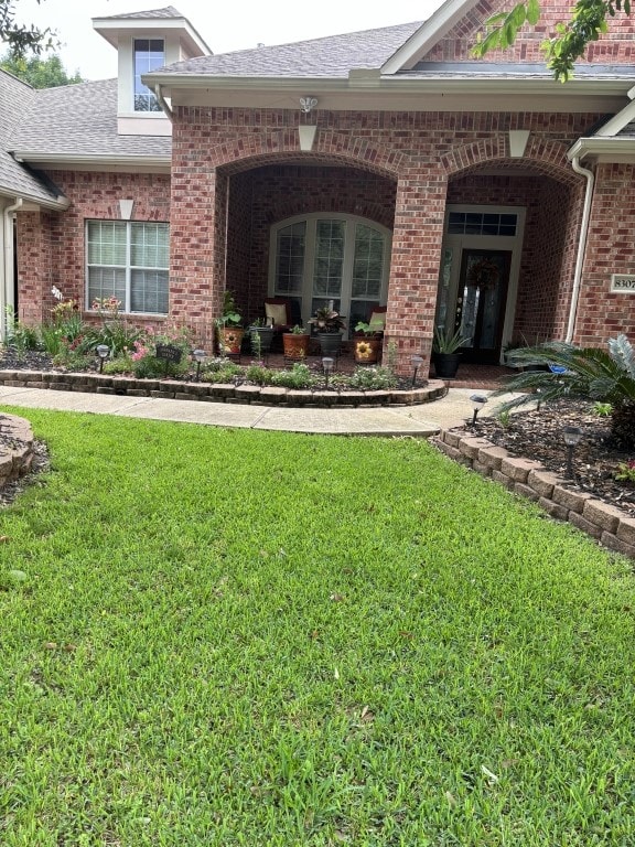 view of exterior entry with a lawn