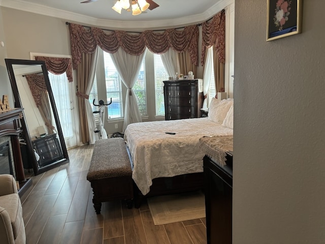 bedroom featuring hardwood / wood-style flooring, ornamental molding, and ceiling fan