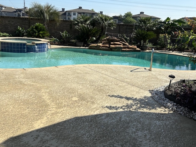 view of swimming pool featuring an in ground hot tub