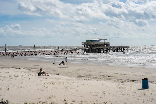 view of property's community with a water view and a view of the beach