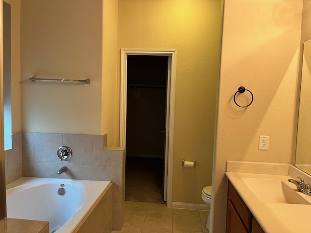 bathroom with vanity, tiled bath, tile patterned floors, and toilet