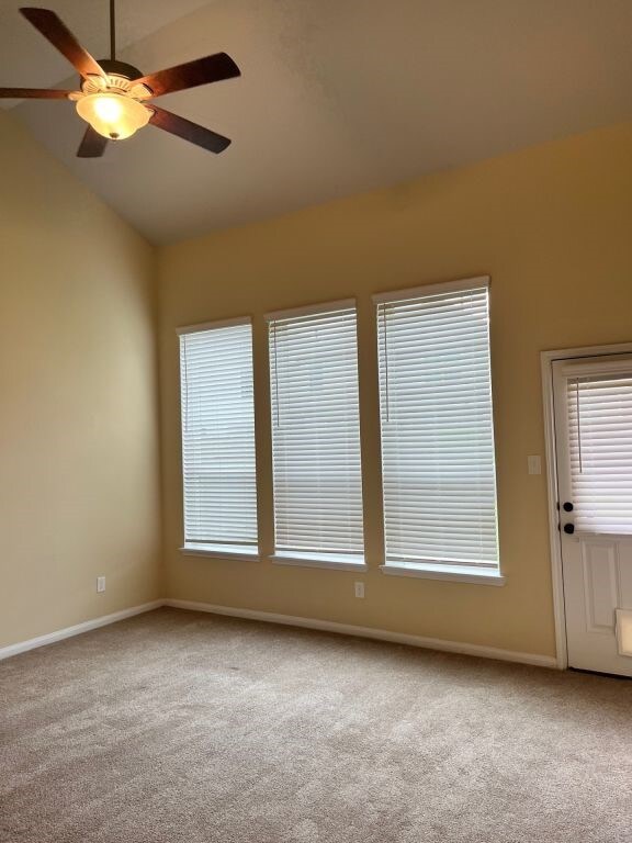 empty room featuring carpet flooring, lofted ceiling, and ceiling fan