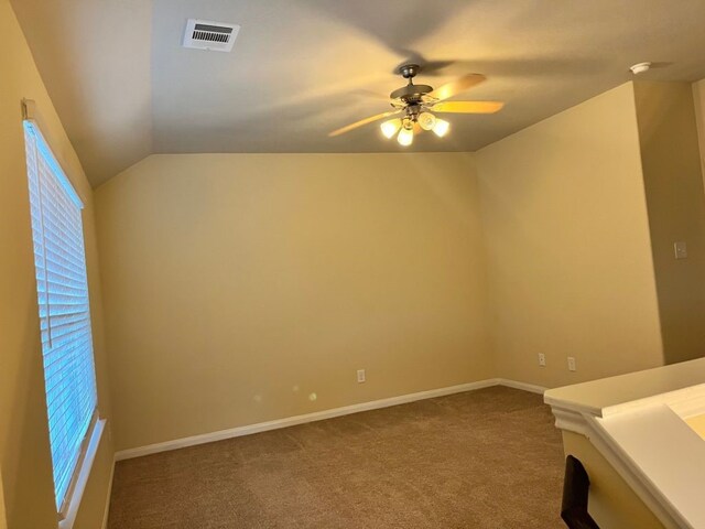 unfurnished room featuring vaulted ceiling, carpet floors, and ceiling fan