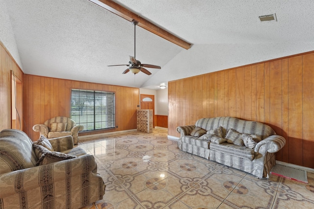 tiled living room with a textured ceiling, wooden walls, and ceiling fan