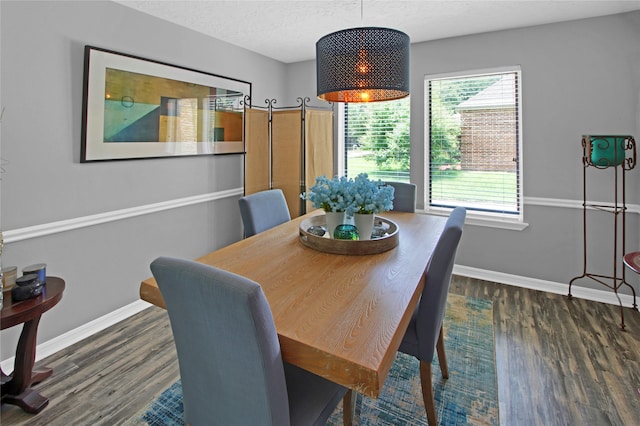 dining space featuring dark hardwood / wood-style flooring and a textured ceiling