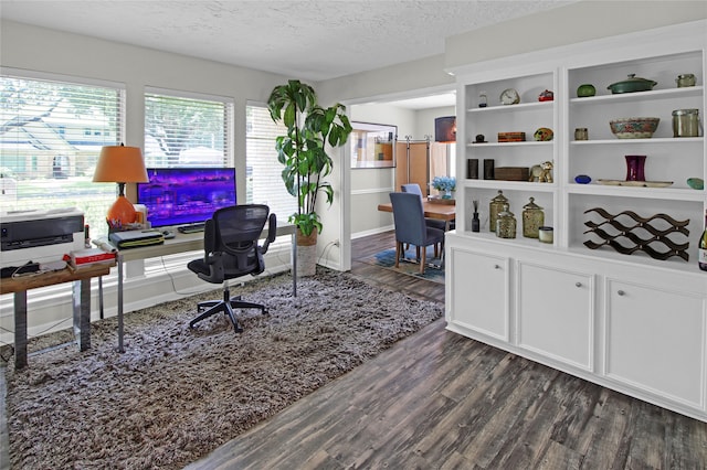 office space featuring dark wood-type flooring, built in features, and a textured ceiling