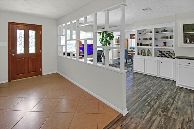 tiled foyer entrance with a textured ceiling