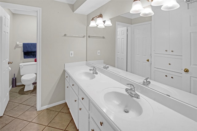 bathroom featuring toilet, tile patterned floors, and double sink vanity