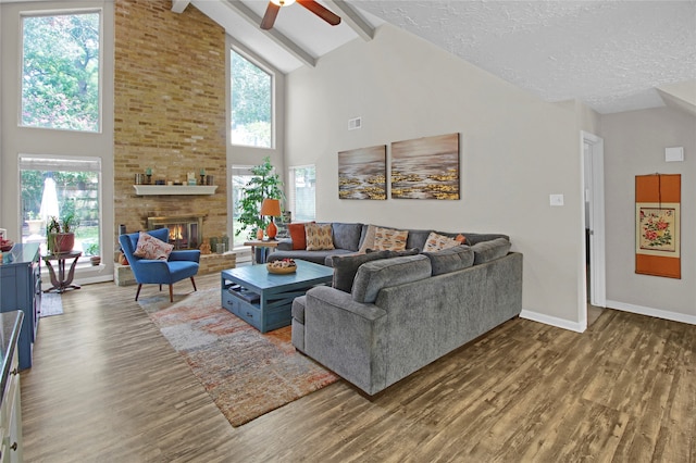 living room featuring high vaulted ceiling, a fireplace, wood-type flooring, and beam ceiling