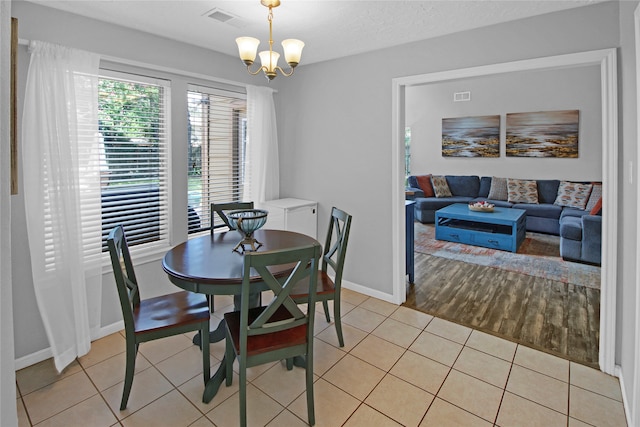 dining room with an inviting chandelier and light tile patterned floors