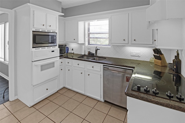 kitchen featuring white cabinetry, decorative backsplash, sink, appliances with stainless steel finishes, and light tile patterned floors