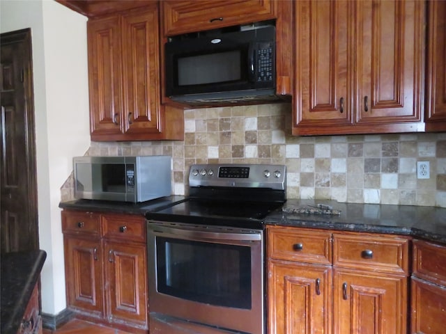 kitchen with dark stone counters, stainless steel appliances, and tasteful backsplash