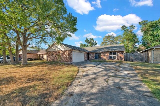 ranch-style home featuring concrete driveway, a front lawn, brick siding, a garage, and fence