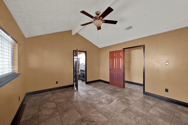 empty room featuring ceiling fan, a textured ceiling, and vaulted ceiling with beams