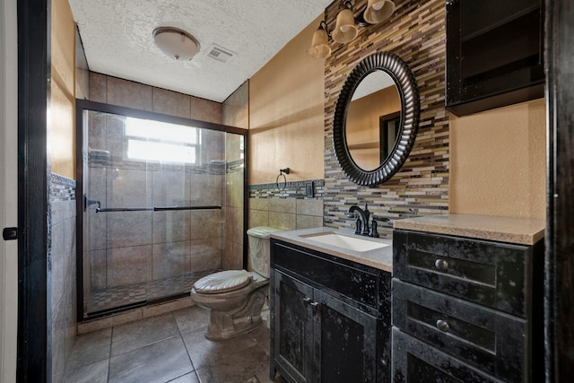 bathroom featuring vanity, a shower with shower door, a textured ceiling, and toilet